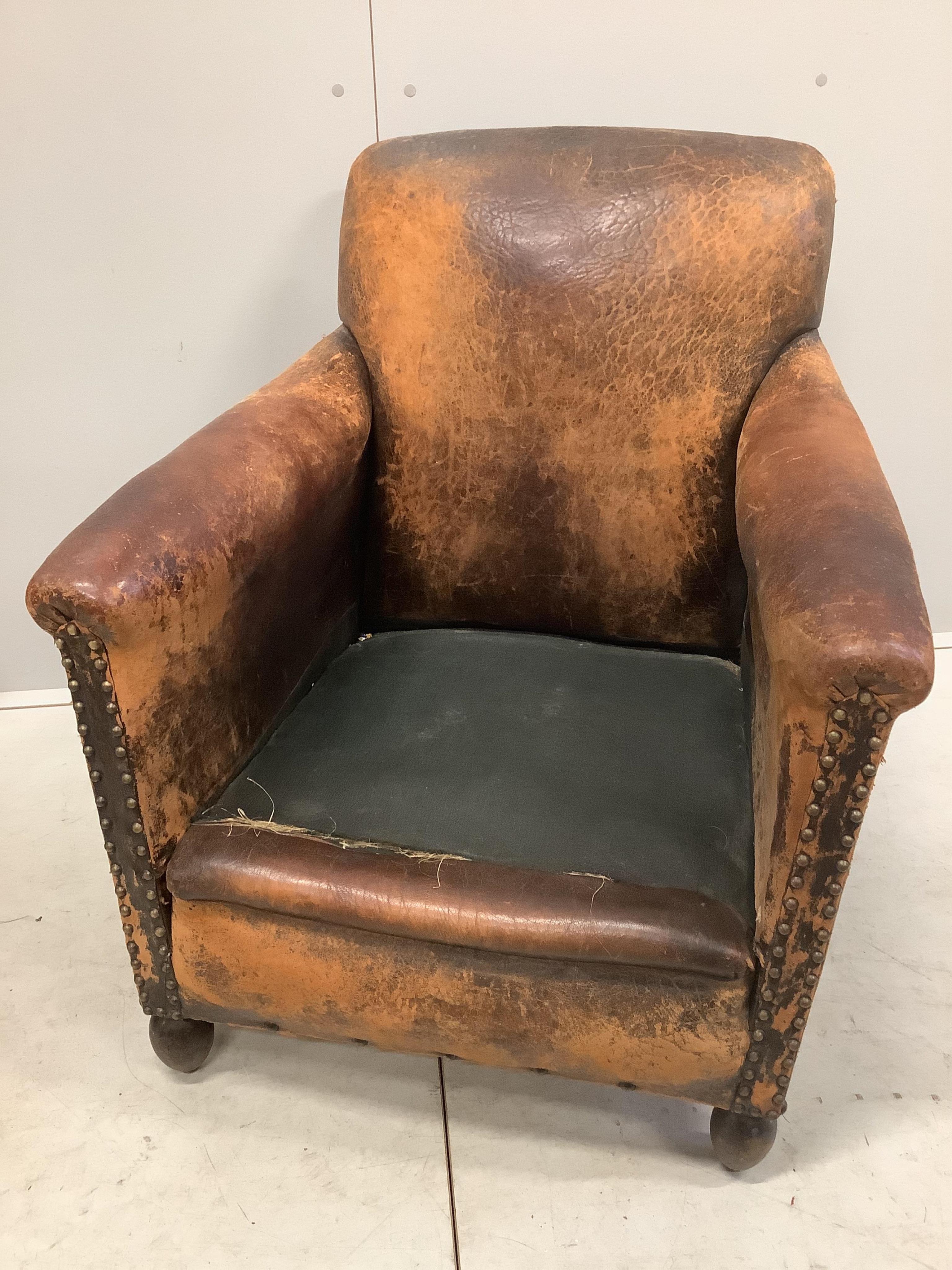 A pair of early 20th century French leather club armchairs, width 73cm, depth 74cm, height 83cm. Condition - poor to fair